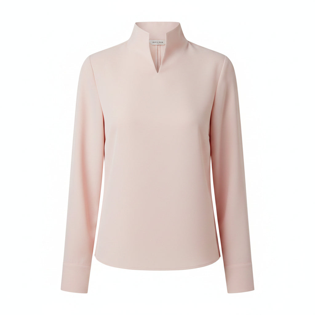 Person wearing a light pink blouse with a blurred background