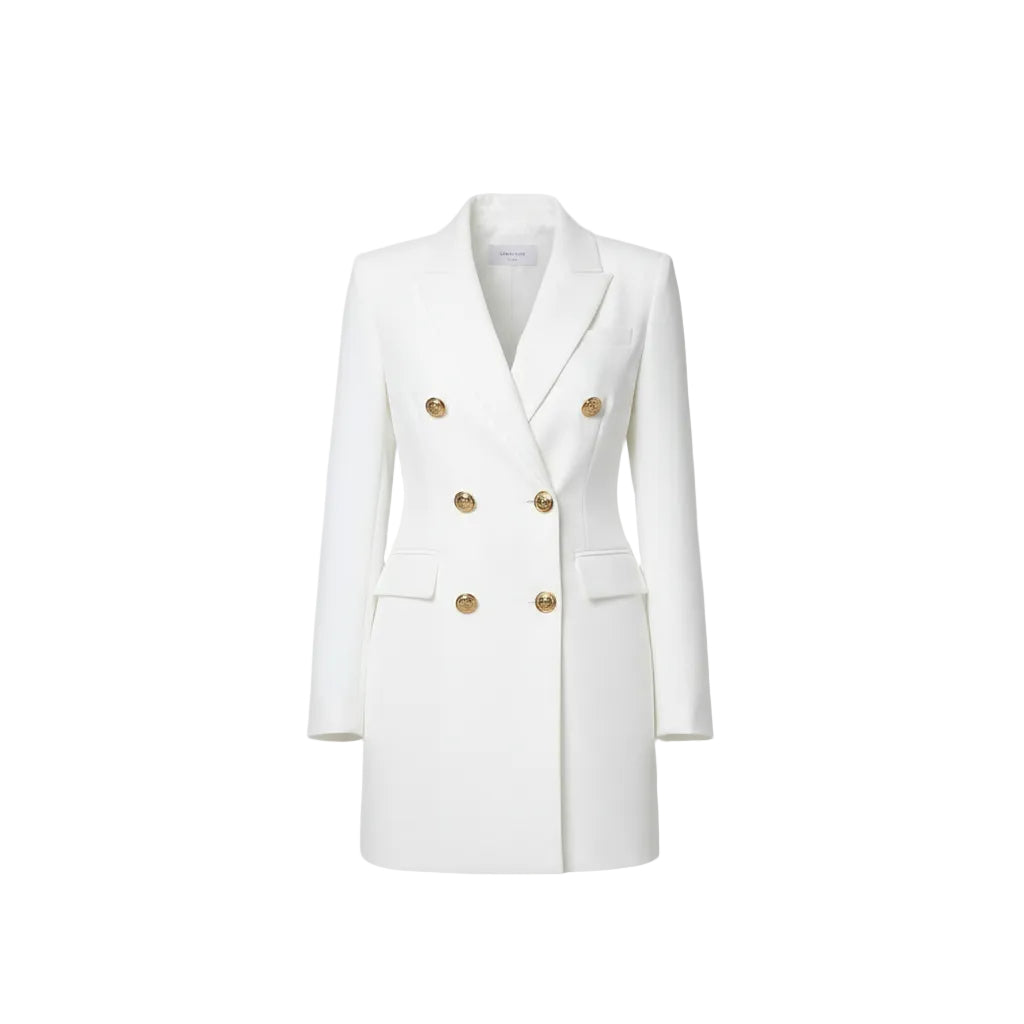 Woman wearing a white blazer dress with gold buttons in an outdoor setting.