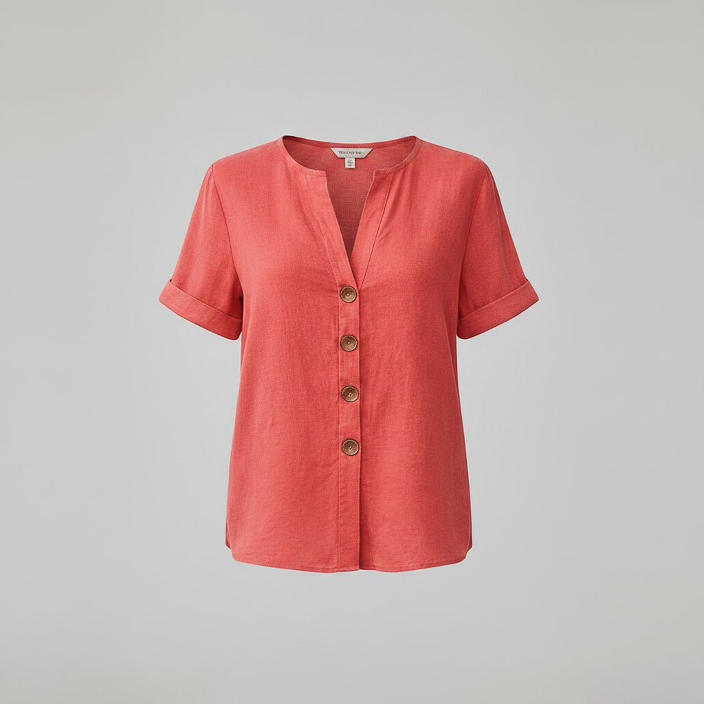 Person wearing a coral-colored button-up shirt with a neutral background