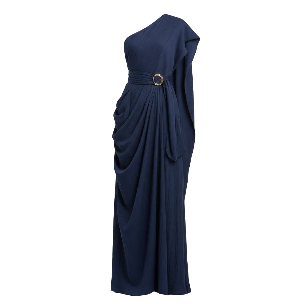 Woman wearing a navy blue one-shoulder dress against a beige wall.