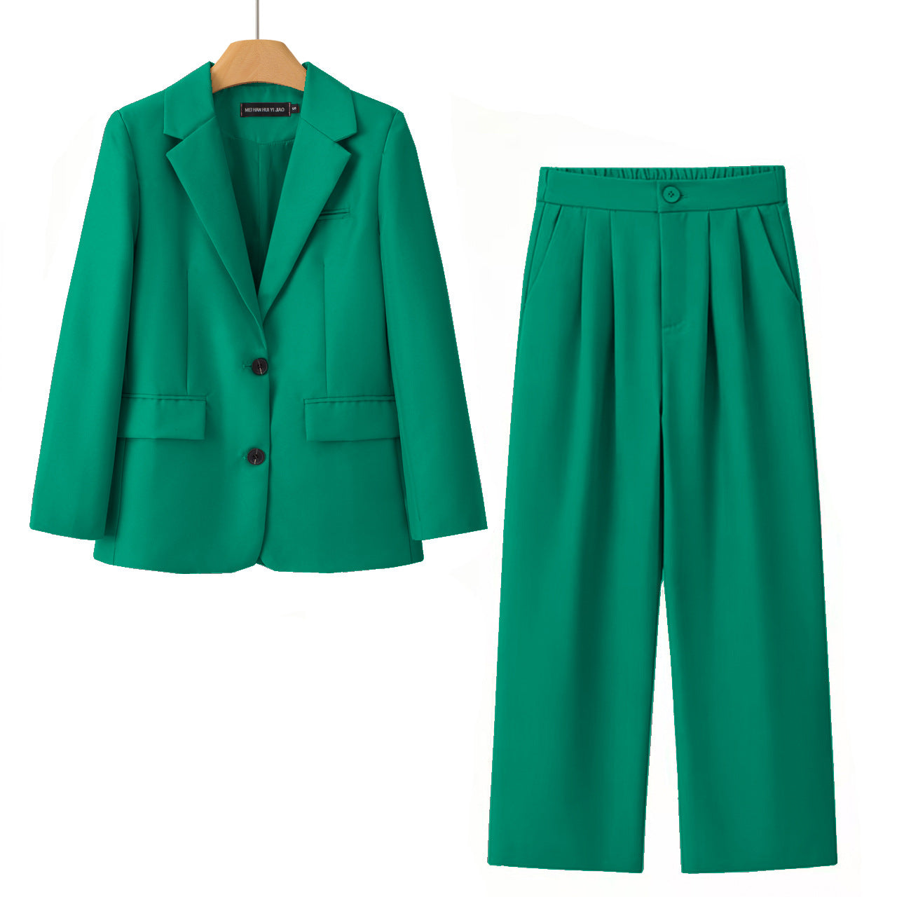 A two-piece women's suit set in a vibrant emerald green color, featuring a single-breasted blazer on a wooden hanger and matching pleated wide-leg trousers, displayed against a solid white background.