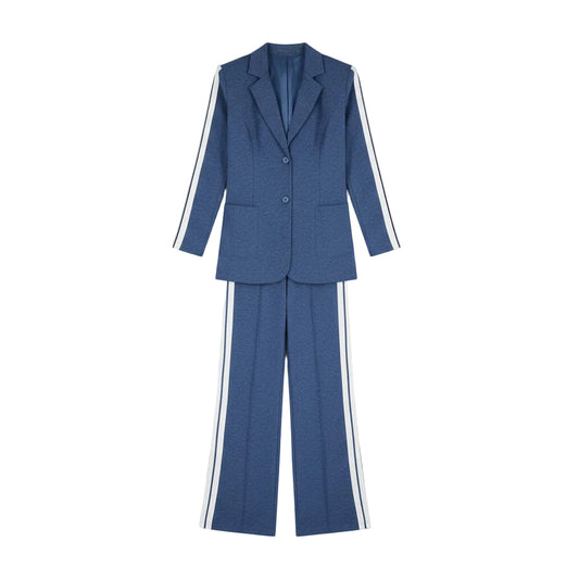 Woman in a blue suit with white stripes standing in front of a wardrobe.
