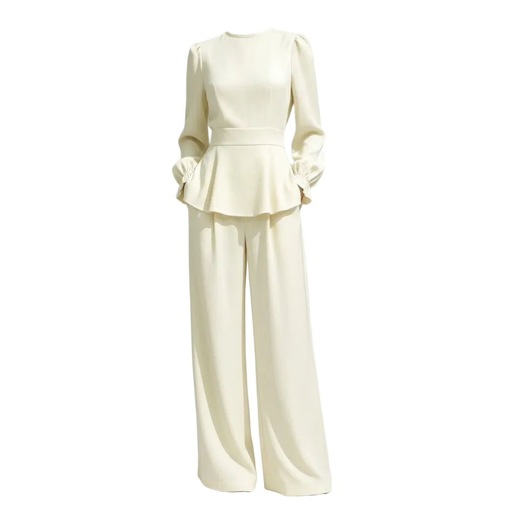 Person wearing a cream-colored outfit with a peplum top and wide-leg pants against a white textured wall.