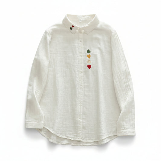 White shirt with colorful heart designs on a wooden surface