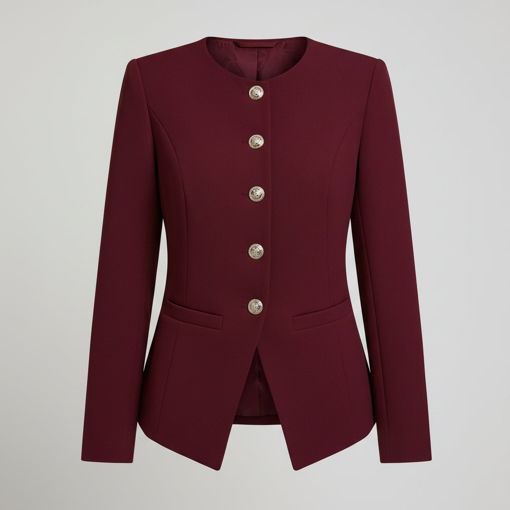 A woman wearing a long-sleeve burgundy blazer with decorative silver buttons down the front and black pants, shown from the neck down against a dark background.