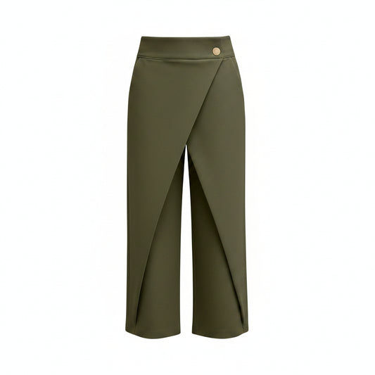 A model wearing olive green wrap-style cropped pants with a single gold button at the waist, paired with a white long-sleeve blouse and silver heels, against a solid gray studio background.