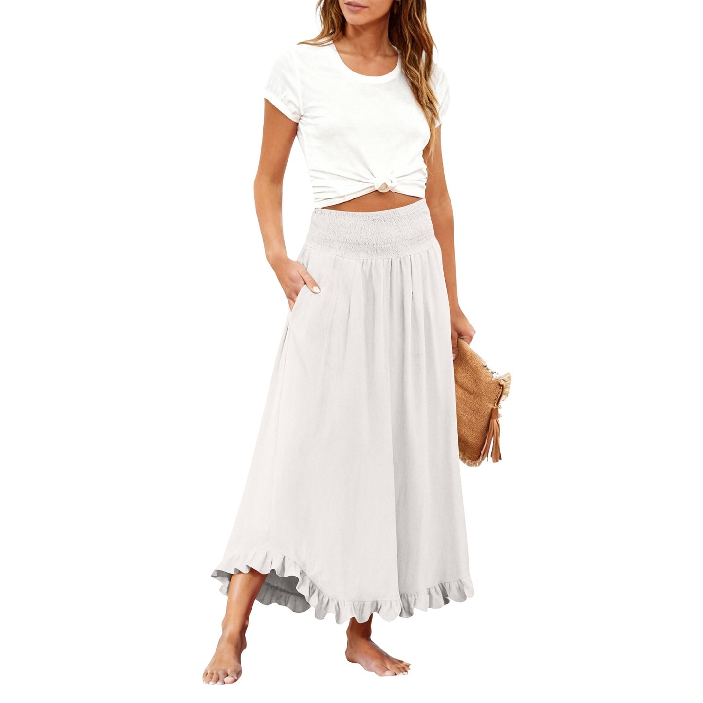 Woman wearing a white top and skirt with a straw bag on a white background