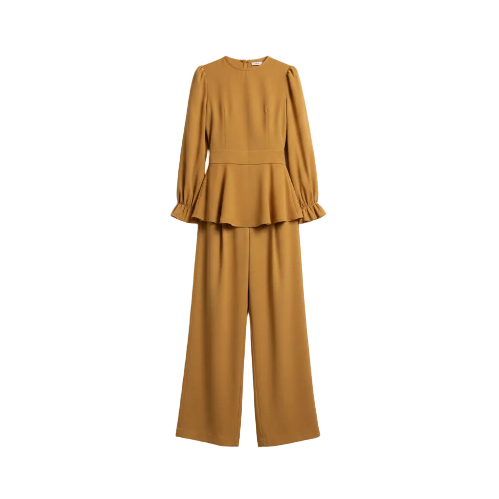 Mustard yellow outfit with a peplum top and wide-leg pants against a white marble background