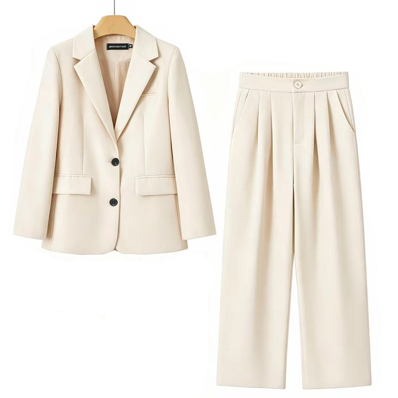 A women's two-piece suit set in cream/off-white, featuring a single-breasted blazer with notch lapels and dark buttons, paired with high-waisted pleated trousers, shown on a white background.