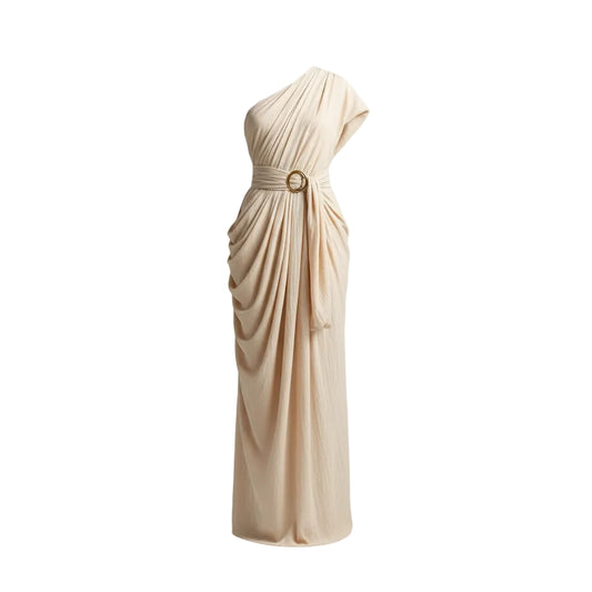 Woman wearing a flowing beige dress against a textured beige wall.